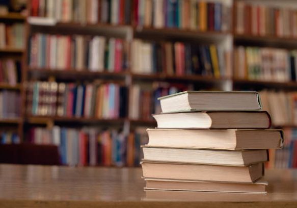 Close up of books on desk in library.